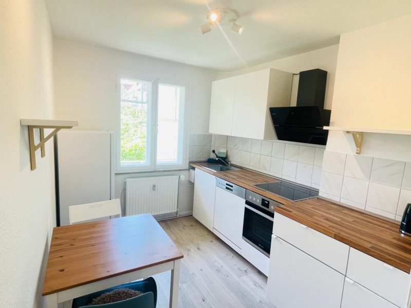 Küche mit Kühlschrank, Herd, Backofen und Spülmaschine
